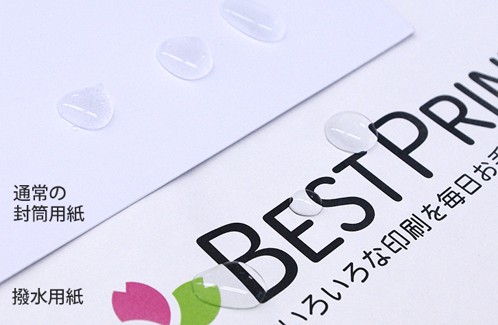 通常の封筒用紙と撥水用紙の上に水滴が乗っている写真。どちらも水滴が丸く保たれている状態。